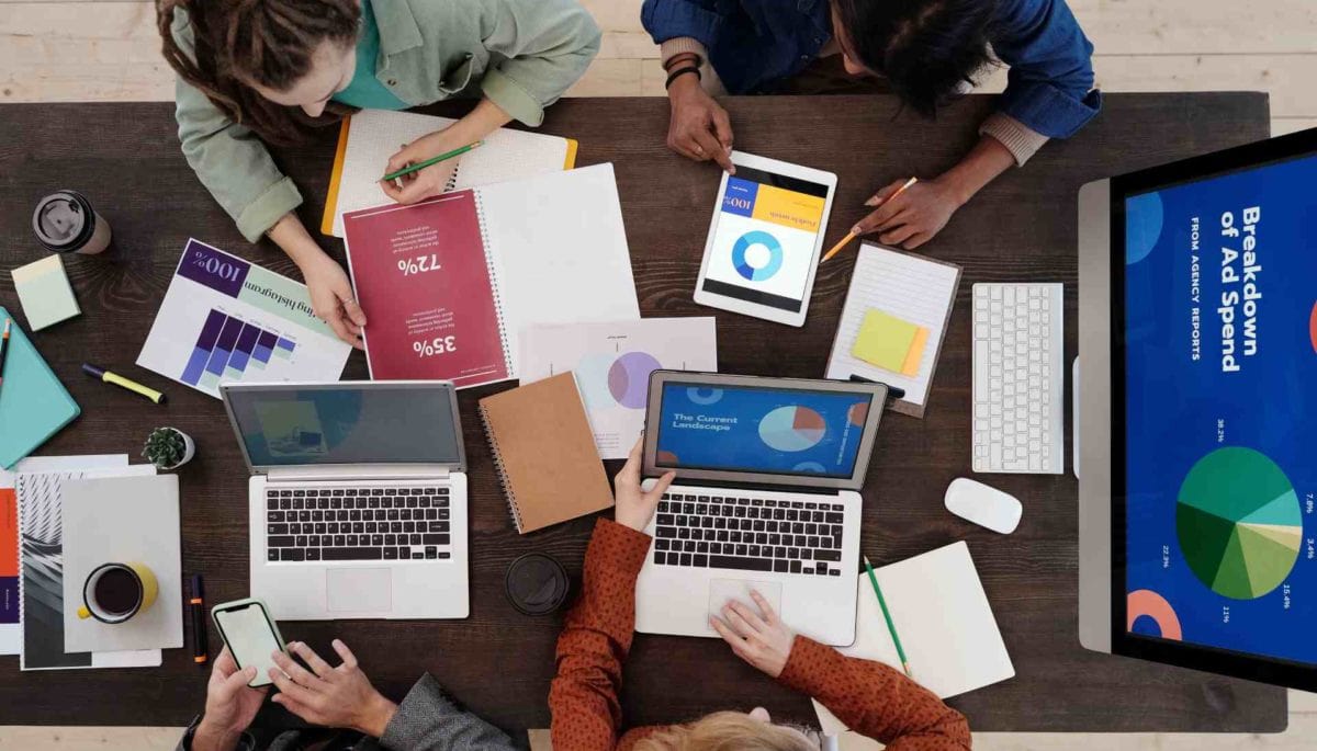 Personas trabajando con sus computadoras ofreciendo distintos servicios digitales